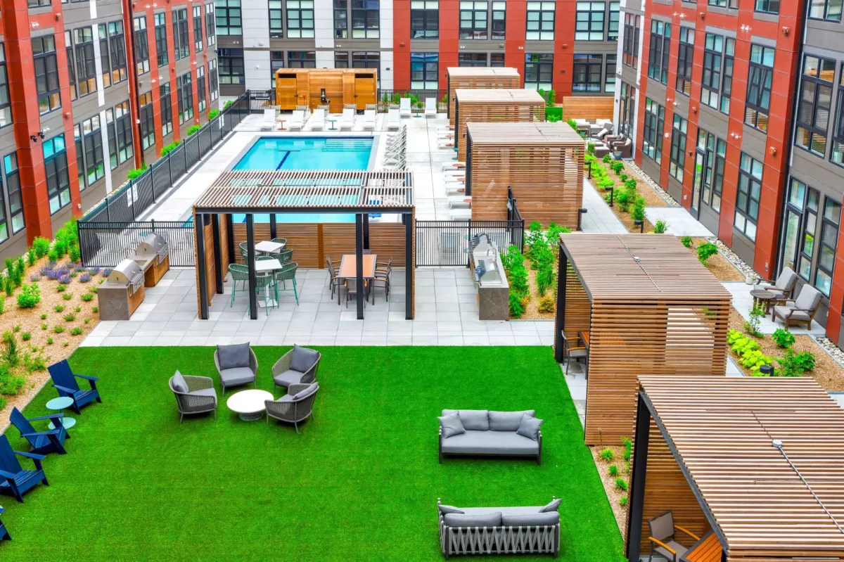 Courtyard lawn with outdoor seating, grills, and poolside cabanas.