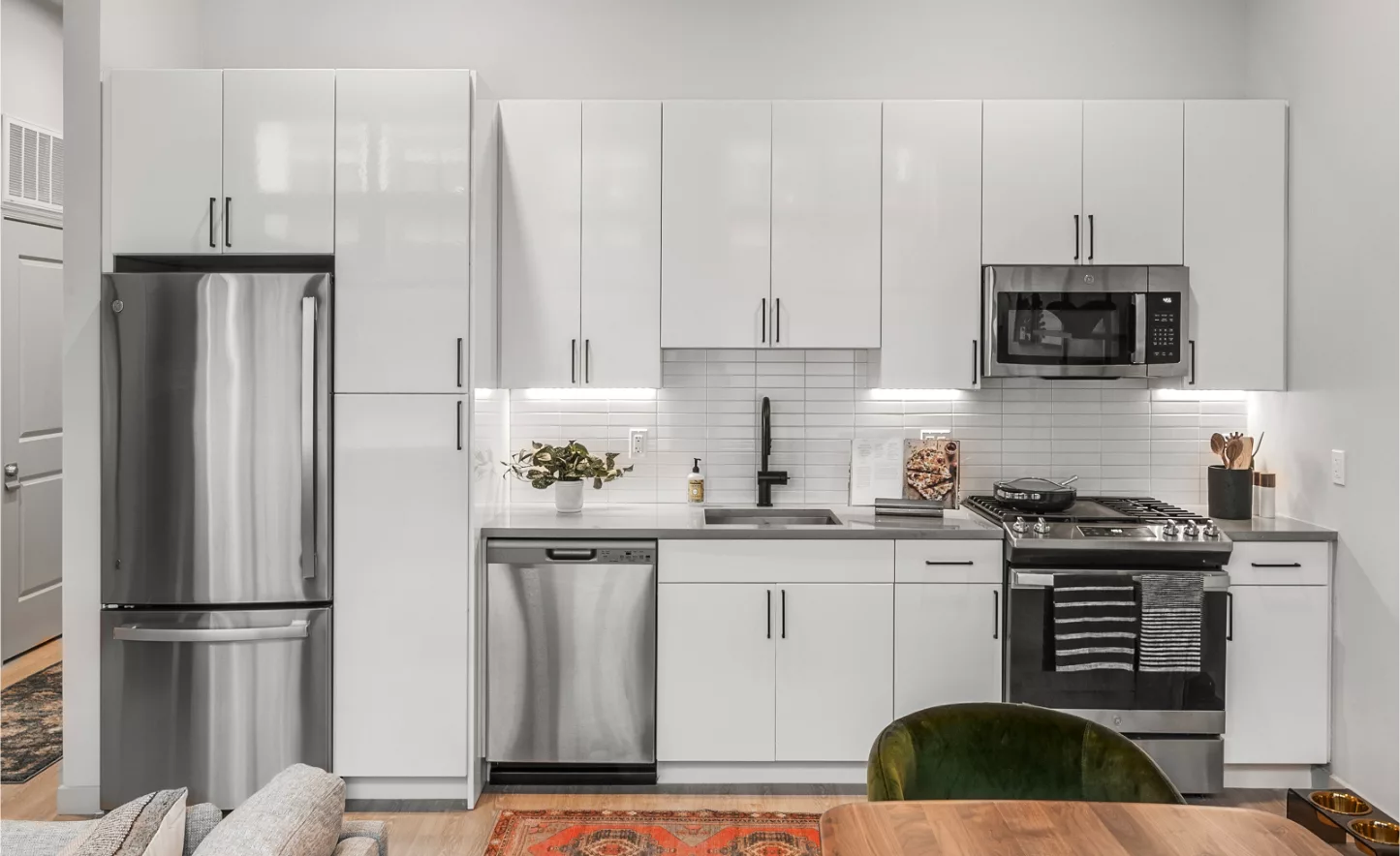 Modern kitchen with white cabinetry, stainless steel appliances, and subway tile backsplash.