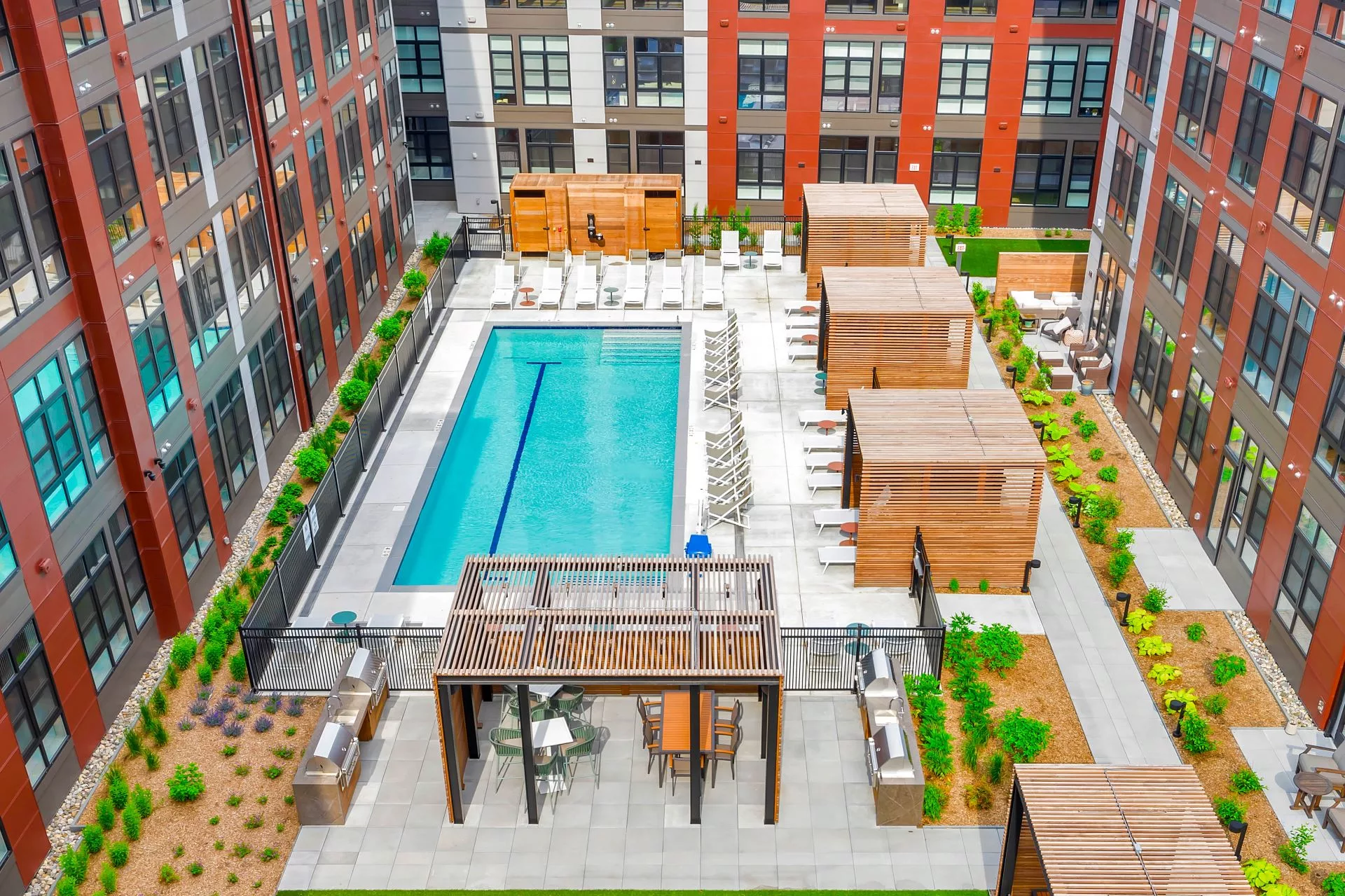 Courtyard with pool, lounge chairs, cabanas, and landscaped paths.